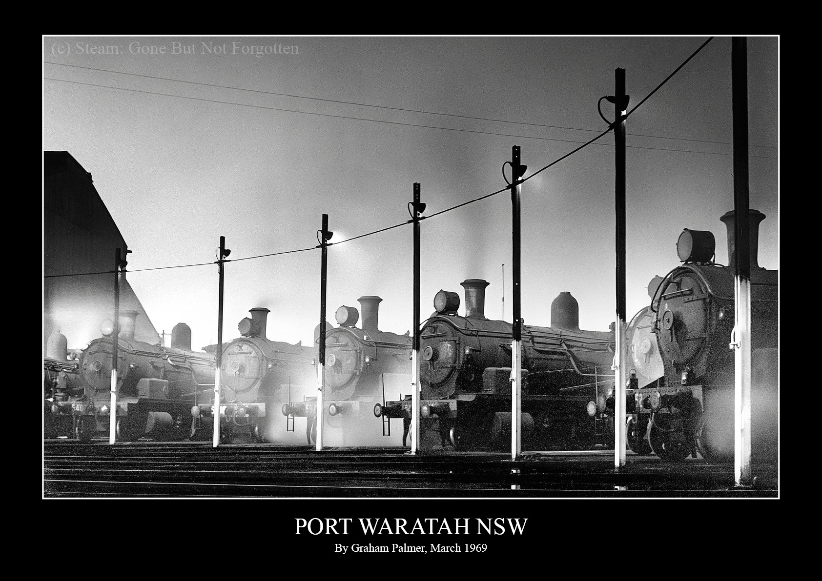 Steam locomotives lined up at night at Port Waratah, NSW, March 1969, lit against the dark by Graham Palmer.